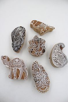 several wooden carved animals sitting on top of a white table next to eachother