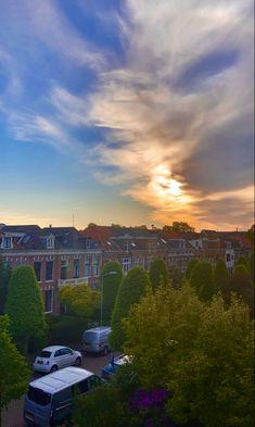 the sun is setting over some buildings and cars