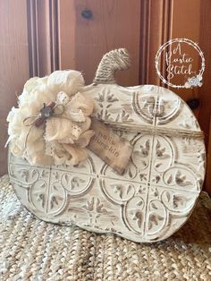 a white pumpkin shaped box with a flower on it