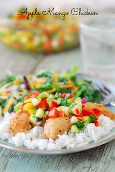 a white plate topped with rice covered in veggies and chicken next to a glass of water