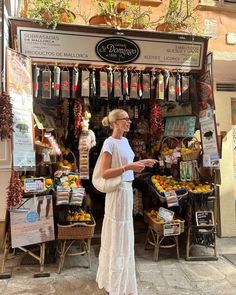 a woman standing in front of a fruit stand