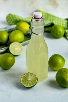 a bottle of limeade next to some limes