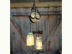 two mason jar lights hanging from a chain