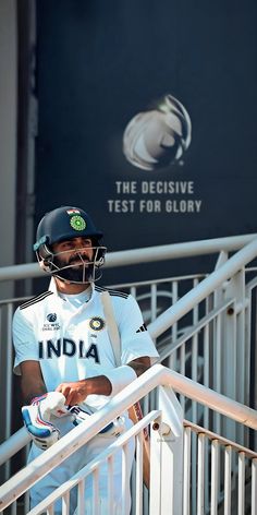 a man wearing a helmet and holding a cricket bat in his hand while walking down some stairs