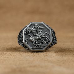 Saint George of Lydda Men Signet Ring, St George with Dragon Ring, St George Christian Ring, Religious Gift Ring For Family, Wedding Gifts   Made of 925 silver and handcrafted by hand, this ring is not only an accessory piece that complements your daily elegance, but also has details that will reflect your character and style. It is also a great gift to give to your loved ones on their special days. At SavisSilver, we always give importance to the satisfaction of our customers, we recommend you Wedding Rings Engraved Metal, Engraved Metal Wedding Rings, Men Signet Ring, Christian Ring, Dragon Ring, Signet Rings, Saint George, Men Jewelry, Family Wedding