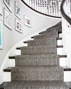 a staircase with pictures on the wall and carpeted steps leading up to the second floor