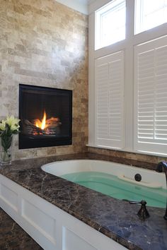 a bathroom with a jacuzzi tub next to a fire place in the fireplace