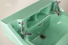 a mint green sink with chrome faucet and soap dispenser