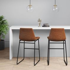 two brown chairs sitting at a white table