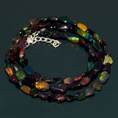 multicolored glass beaded bracelet with silver plated clasp on black table top