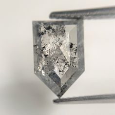 a diamond that is sitting on top of a piece of metal with black and white speckles