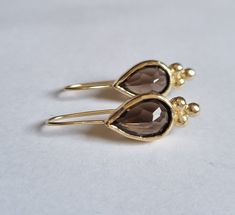 "These Vintage inspired 14k gold teardrop earrings were designed and set with beautiful, seethrough pear shaped Smokey quartz gemstones. The Gold Smoky earrings are 100% handmade and are romantic, elegant and beautiful. The gold drop earrings are shaped as teardrops, with a triangle of 3 golden dots at the edge of every such drop. The 14k gold earrings are a great gift for yourself or a women you love, they are simple but chic and will elevate any outfit you choose to wear- casual or elegant. Th Elegant Briolette Teardrop Earrings Gift, Elegant Handmade Teardrop Pendant Drop, Elegant Hypoallergenic Briolette Teardrop Earrings, Elegant Briolette Teardrop Hypoallergenic Earrings, Bridal Earrings Gold, Vintage Inspired Earrings, Brown Earrings, Quartz Gemstones, Earrings Teardrop