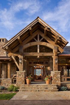 a stone and wood house with potted plants on the front porch