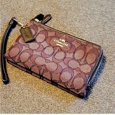 a coach purse laying on the floor with a key chain hanging from it's side