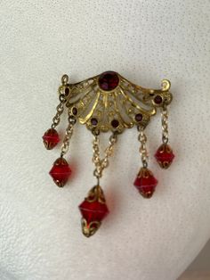 "1920s brooch / antique brooch / 1940s brooch This 1920s brooch is the perfect example of two decades of style. The body of the brooch is a delicate 1920s style brooch with a deep red stone set in the center top. In the 1940s it appears someone wanted to add some dangle to this piece and they added the hanging chains and beads. I love how this piece has been upgraded over the years to become a timeless piece of beautiful. In useable condition. Length 3\" Width 2\"  Condition: Excellent antique c Vintage Brooch For Evening, Vintage Brooch Jewelry For Evening, Vintage Red Wedding Brooches, Vintage Brass Brooch Jewelry, Vintage Filigree Brooches For Formal Occasions, Vintage Filigree Brooches, Vintage Brass Wedding Brooches, Vintage Brass Brooch For Formal Occasions, Vintage Brass Formal Brooches