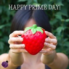 a woman holding up a strawberry in front of her face with the caption happy prime day