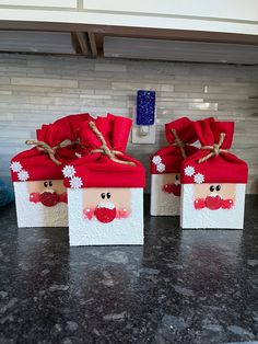 two boxes with santa faces on them are sitting on the kitchen counter, one is wrapped in red and white