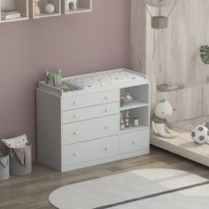 a baby's room with pink walls and white furniture