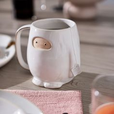 a white mug with a wooden face on it