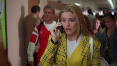 a woman talking on a cell phone while walking down a hallway