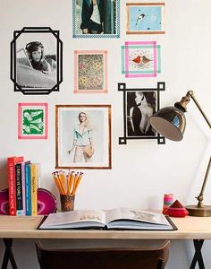 an open book sitting on top of a wooden desk next to a lamp and pictures