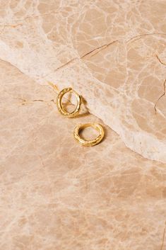 "These hammered huggie hoop earrings are an elevated update to your everyday look.  These 360 degree hoops offer comfortable, chic and effortless flair. Their artisanal quality will take your casual look from blah to sleek chic! Available in gold vermeil (18k gold plating over .925 Silver), Sterling Silver (.925 Silver) and 14K Gold. Sold per pair. Dimensions: 1/2\" (12mm). Thickness is 2mm. Inside diameter is 8mm. Post is 16 gauge (1.2mm). Materials: .925 Silver, 18K Gold Plating, 14K gold Ships in a branded jewelry pouch and box, perfect for gift giving!" Ear Jacket Earring Gold, 70s Earrings, Gold Ear Jacket, Small Gold Hoop Earrings, Sleek Chic, Comfortable Chic, Small Gold Hoops, Ear Jacket Earring, Cartilage Earrings Hoop