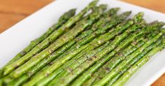 asparagus spears on a white plate ready to be cooked in the oven for dinner