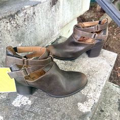 a pair of women's shoes sitting on top of a cement step next to a yellow tag