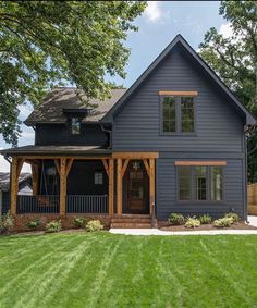 a large blue house sitting on top of a lush green field