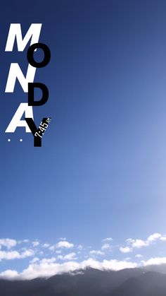 a person flying a kite in the sky with mountains in the back ground and clouds in the background