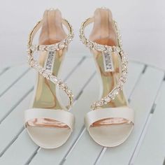 a pair of white high heeled shoes sitting on top of a table