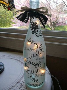 a bottle with some lights in it sitting on a table next to a windowsill