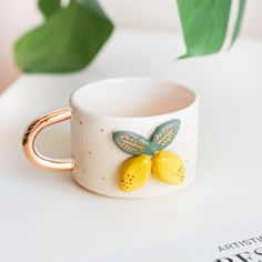 a white cup with two yellow flowers on it