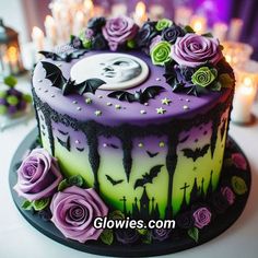 a cake decorated with purple and green icing on a table in front of candles