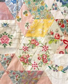 an old quilt with many different colored flowers on the front and back pieces in it