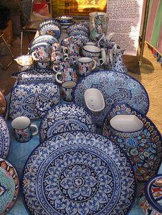 a table topped with lots of blue and white plates