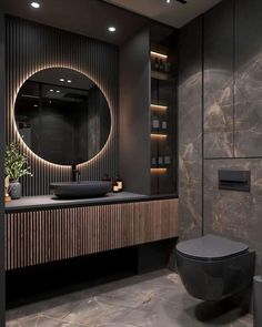 a bathroom with a round mirror and black counter top in front of a marble wall