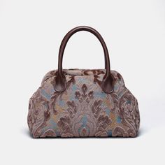 Embrace timeless elegance with our exquisite Victorian Carpet Satchel, a masterpiece meticulously crafted from rich burnout velvet for a luxurious and sophisticated touch. Designed with unique construction, this handbag stands on its own, effortlessly blending style with functionality. Crafted for enduring quality, the bag features genuine leather handles and a sturdy, heavy cotton canvas lining. Each purchase includes a detachable and adjustable shoulder strap, generously measuring 55 inches in length. The strap is skillfully crafted from the same chenille as the bag, and adorned with high-quality bronze hardware for added charm. Perfectly sized for everyday use, our handbag offers ample space to carry your essentials with ease. Stay organized with one zippered pocket, precisely sized at Staud Luxury Satchel Bag, Formal Tapestry Bags, Elegant Tapestry Bags For Everyday Use, Luxury Tapestry Bags For Formal Occasions, Elegant Tapestry Bags With Detachable Handle, Elegant Tapestry Shoulder Bag With Detachable Handle, Elegant Tapestry Bag For Daily Use, Elegant Tapestry Tote Bag, Elegant Rectangular Tapestry Shoulder Bag