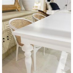 a white table and chairs in a room with a mirror on the wall behind it