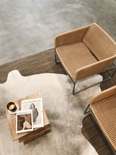 two wicker chairs and a coffee table with magazine on it