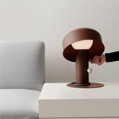 a person is touching the light on a table lamp