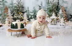 a baby is sitting in front of a cake