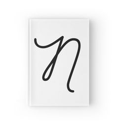 a book with the letter n in black ink on white paper next to a pair of scissors