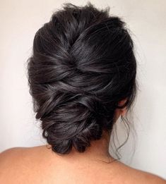 the back of a woman's head, with her hair in a low bun