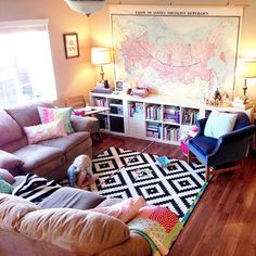 a living room filled with furniture and a large map hanging on the wall above it