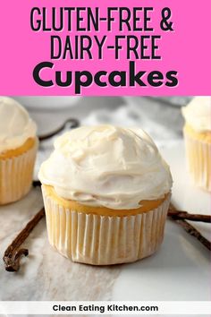 three cupcakes with white frosting sitting on top of a table next to cinnamon sticks