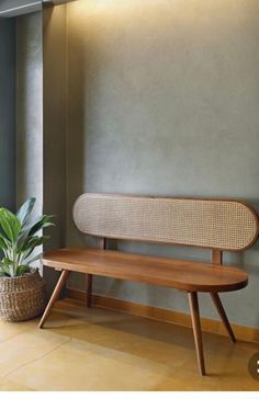 a wooden bench sitting next to a potted plant