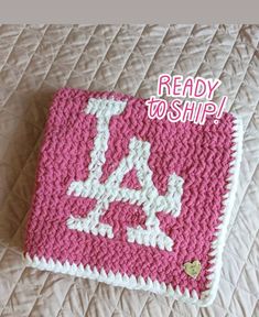 a crocheted pink and white blanket with the words ready to ship on it