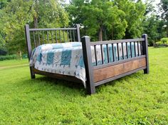 a bed sitting on top of a lush green field