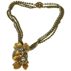 Miriam Haskell Gilt Leaf Pendant Necklace composed of hand sewn rose montees crystals on electroplated leaves and faux pearls. Chaining is of 2 gilt chains mixed with a rhinestone chain. Signature filigree clasp, signed Miriam Haskell. 1950's USA. Excellent condition. Chain 14", Pendant 2" x 1". Gold Embellished Evening Necklaces, Gold Embellished Evening Necklace, Miriam Haskell Jewelry, Rhinestone Chain, Miriam Haskell, Metal Leaves, Leaf Pendant, Nice Things, Drop Necklace